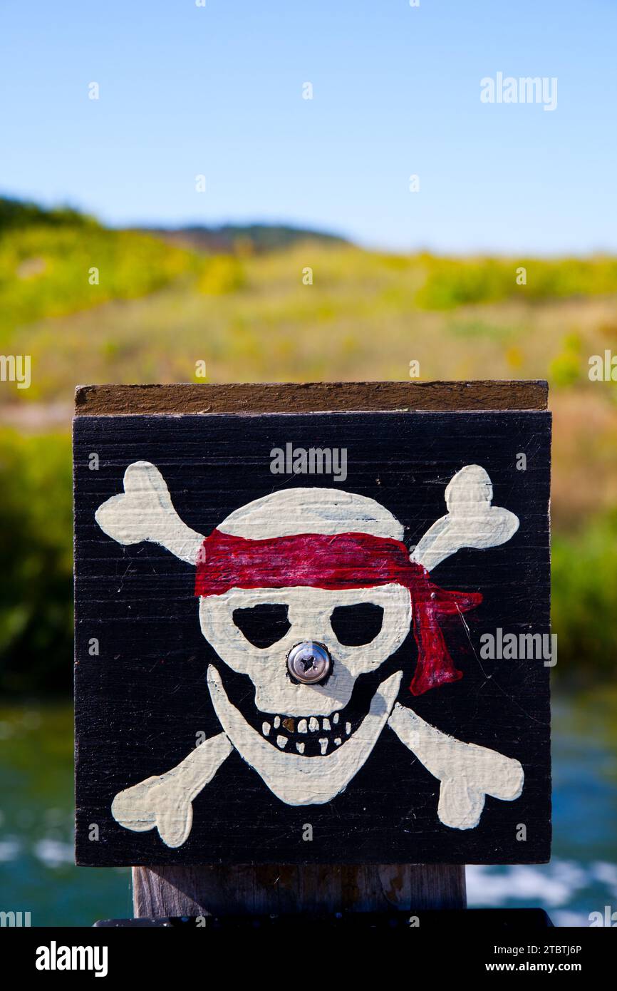 Pirate flag Jolly Roger in silk fabric texture. Calico Jack Rackham historical model Stock Photo Pirate flag Jolly Roger in silk fabric texture. Calico Jack Rackham historical model Stock Photo