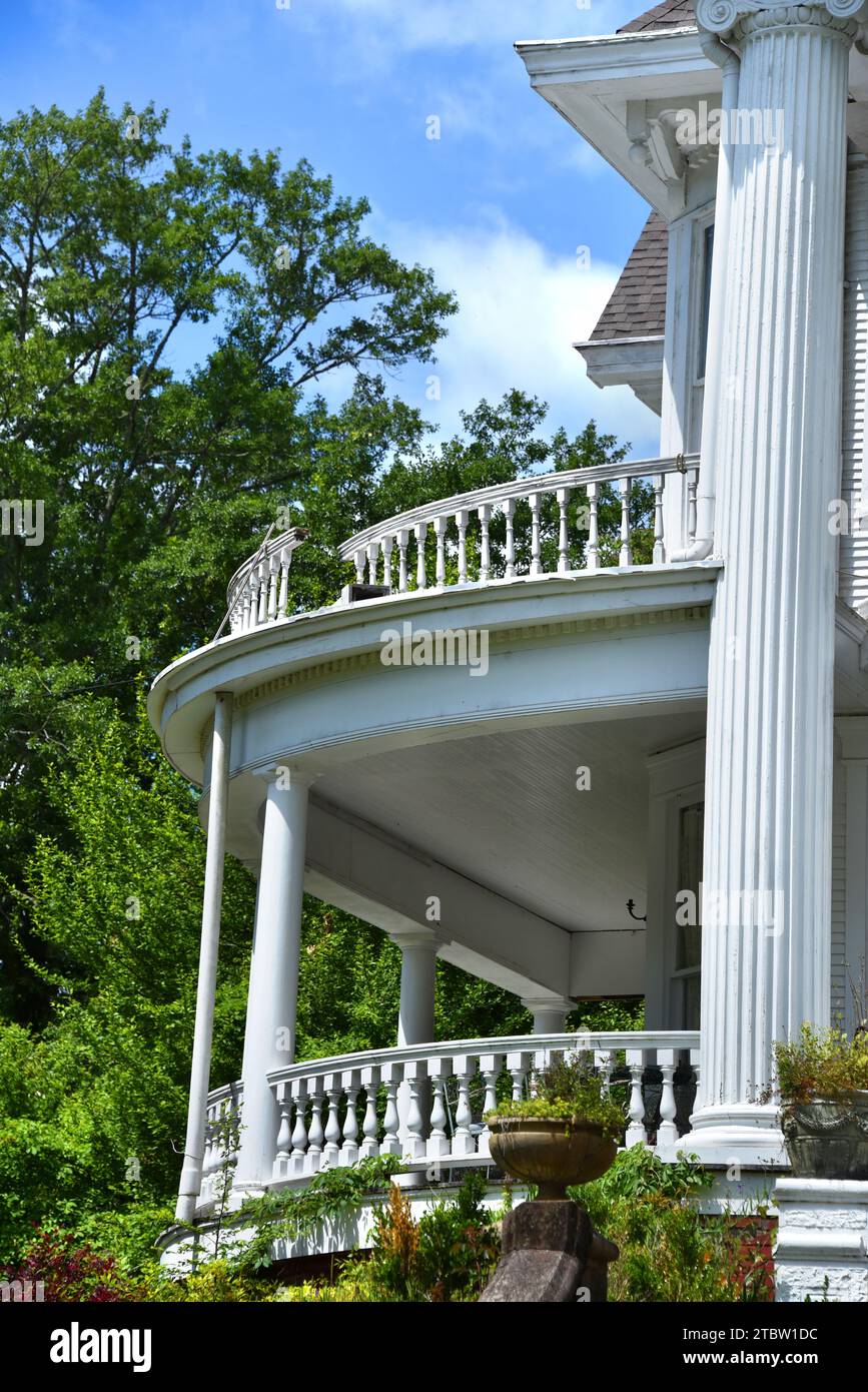 Bella casa anteguerra ha rotto ringhiera su ringhiera sul balcone di secondo piano. Elegante portico rotondo con mandrini in legno. Foto Stock