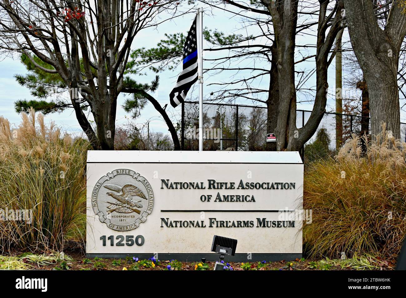 Fairfax, Virginia, Stati Uniti d'America - 7 dicembre 2023: Insegna all'edificio della National Rifle Association e del National Firearms Museum con la bandiera "Thin Blue Line". Foto Stock