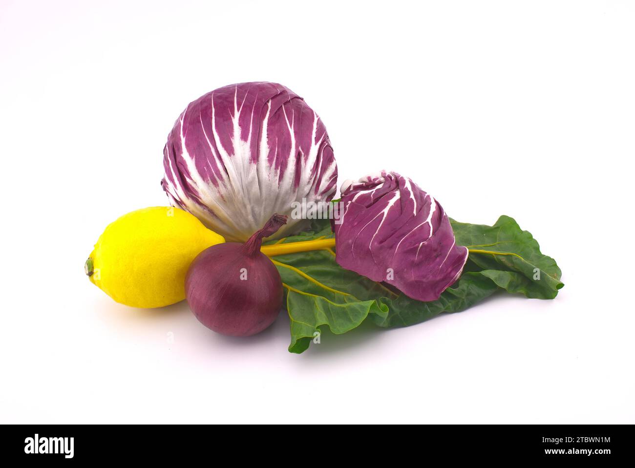 Assortimento di freschi e colorati tra cui barbabietole, limone, insalata di radicchio, cipolla e aglio isolato su sfondo bianco Foto Stock