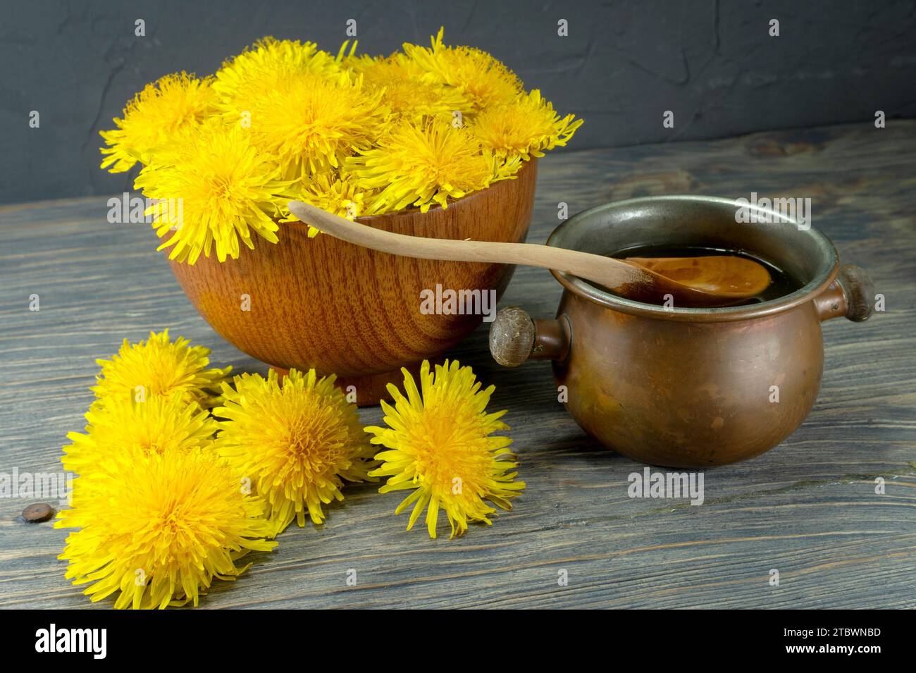 Vasetto di miele di sgocciolamento un cucchiaio con colorati molla gialla di tarassaco a fianco in una dieta sana nozione Foto Stock