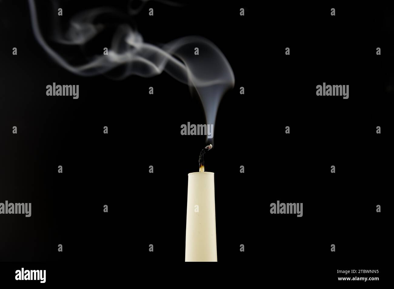Il fumo di una candela bianca spenta su sfondo nero Foto Stock