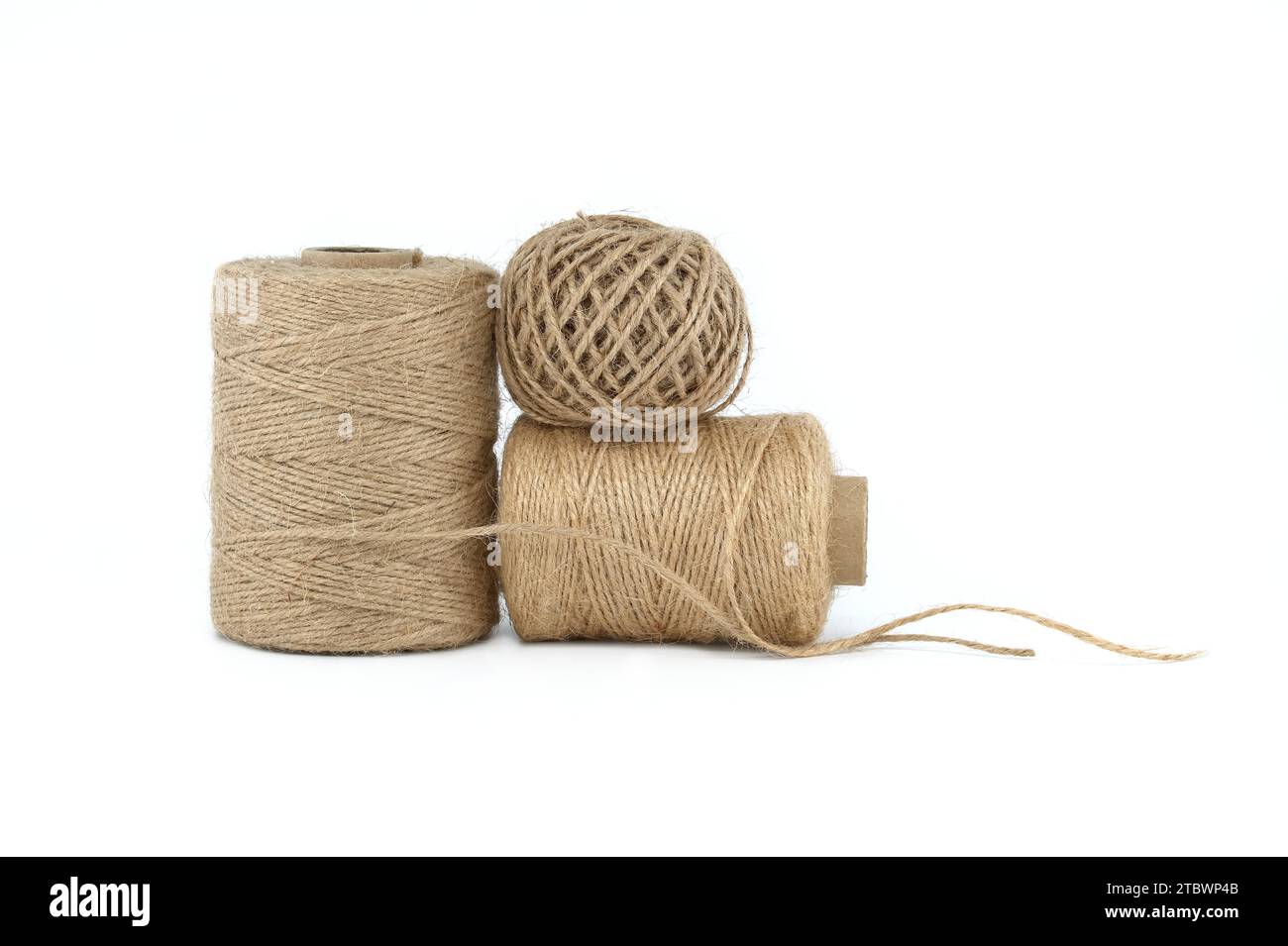 Bobine di fili di tela o spago di iuta isolate su sfondo bianco. Materiale biodegradabile ecologico Foto Stock
