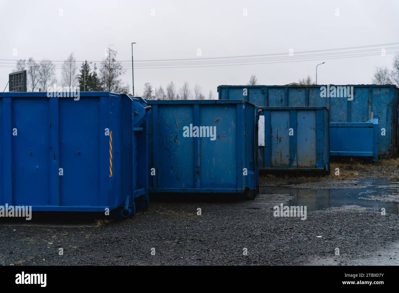 Gruppo di grandi contenitori per rifiuti industriali su ghiaia Foto Stock