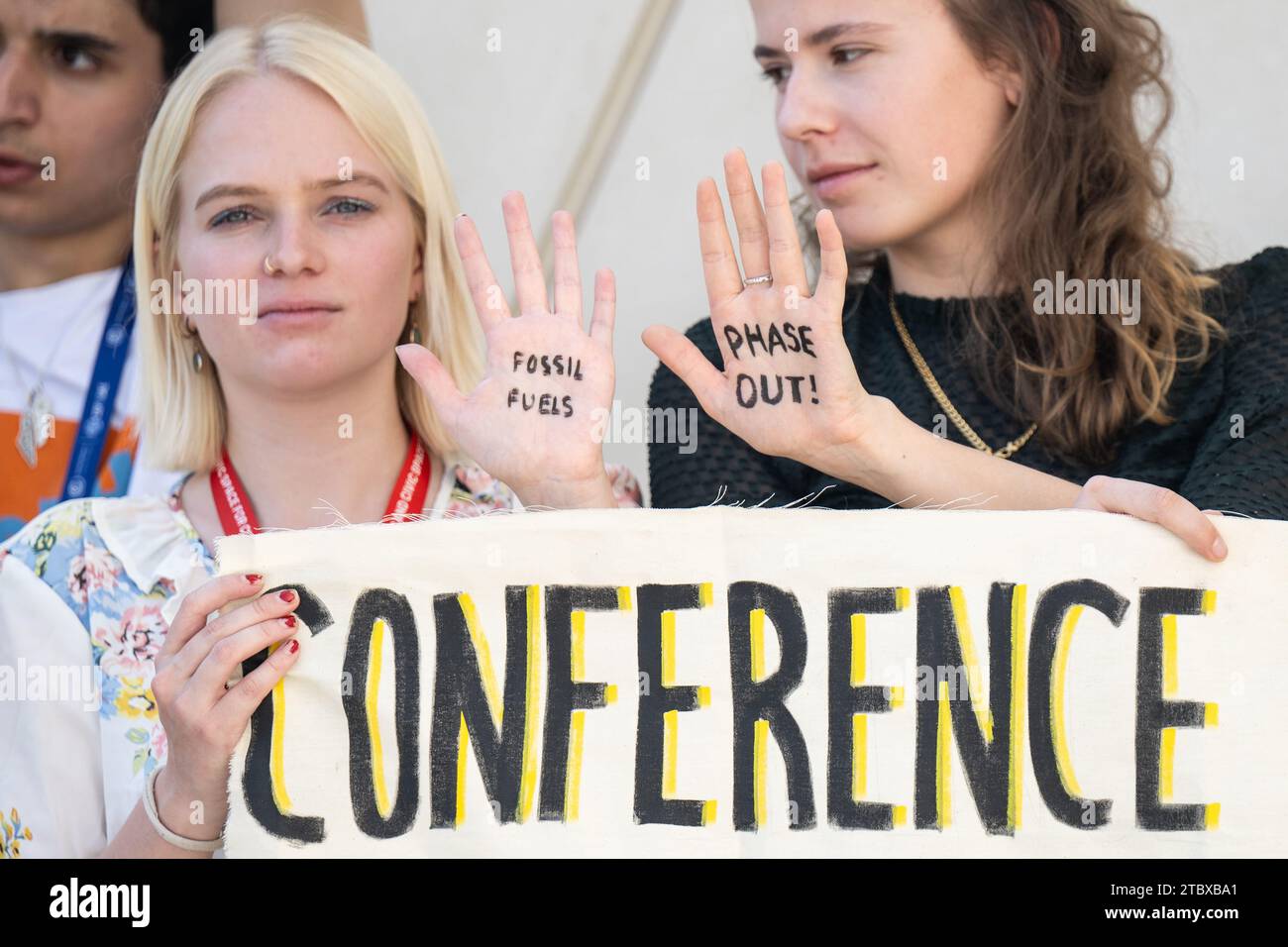 Dubai, Emirati Arabi Uniti. 9 dicembre 2023. Luisa Neubauer (r), attivista per il clima e dimostratrice hanno 'combustibili fossili' e 'Phase Out!' scritto sulle loro mani. I temi principali della conferenza ONU sui cambiamenti climatici di quest'anno includono il finanziamento dei danni causati dai cambiamenti climatici. Credito: Hannes P. Albert/dpa/Alamy Live News Foto Stock