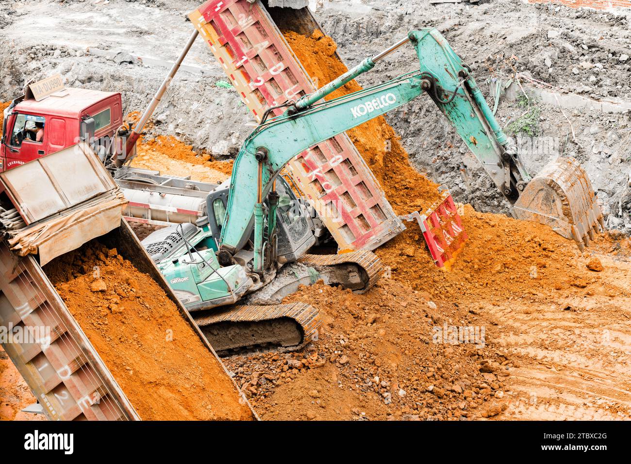 Escavatore che scava il terreno all'interno del cantiere Foto Stock