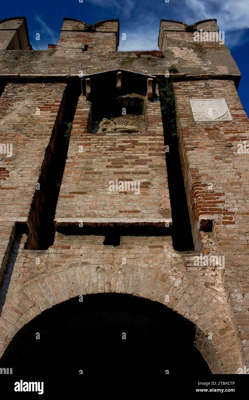 Porta d'ingresso al Castello Scaligero medievale o alla Rocca Scaligera a Sirmione sul Lago di Garda in Lombardia. Costruito nel 1300, il castello prende il nome dalla famiglia della Scala, dinastia regnante di Verona, che dominava la zona all'epoca. In una nicchia a timpano (centro superiore), sotto un corso d'archi, si trova un leone alato di San Marco, emblema della Repubblica di Venezia, che fu aggiunto in seguito. Foto Stock
