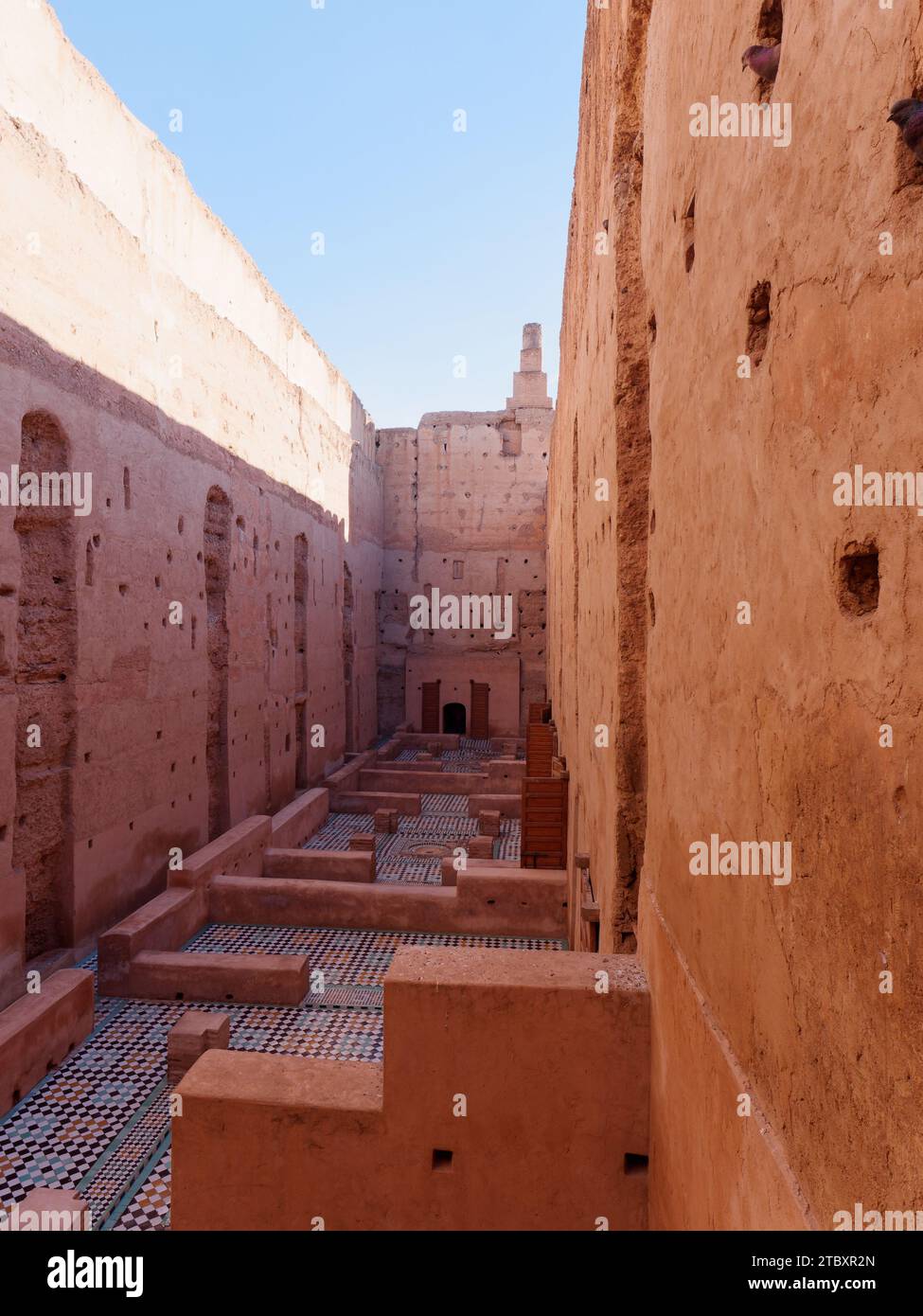 Cortile con alte pareti in terra con pavimenti piastrellati nel Palazzo Badi mentre gli uccelli si fanno strada. Marrakech, alias Marrakech, Marocco, 09 dicembre 2023 Foto Stock