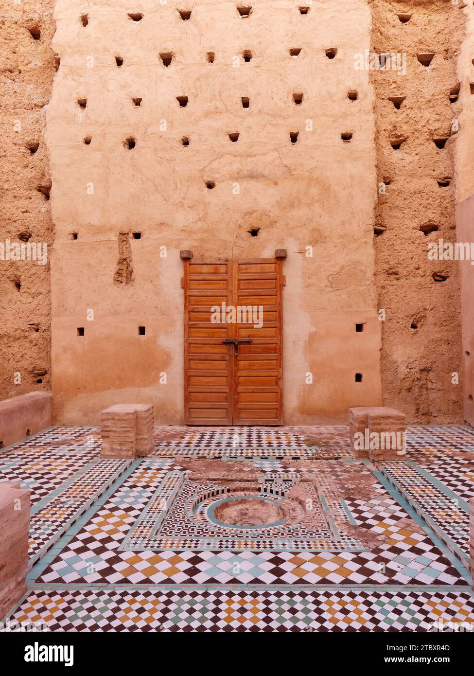 Cortile con alte pareti in terra con pavimenti piastrellati nel Palazzo Badi nella città di Marrakech, alias Marrakech, Marocco, 9 dicembre 2023 Foto Stock