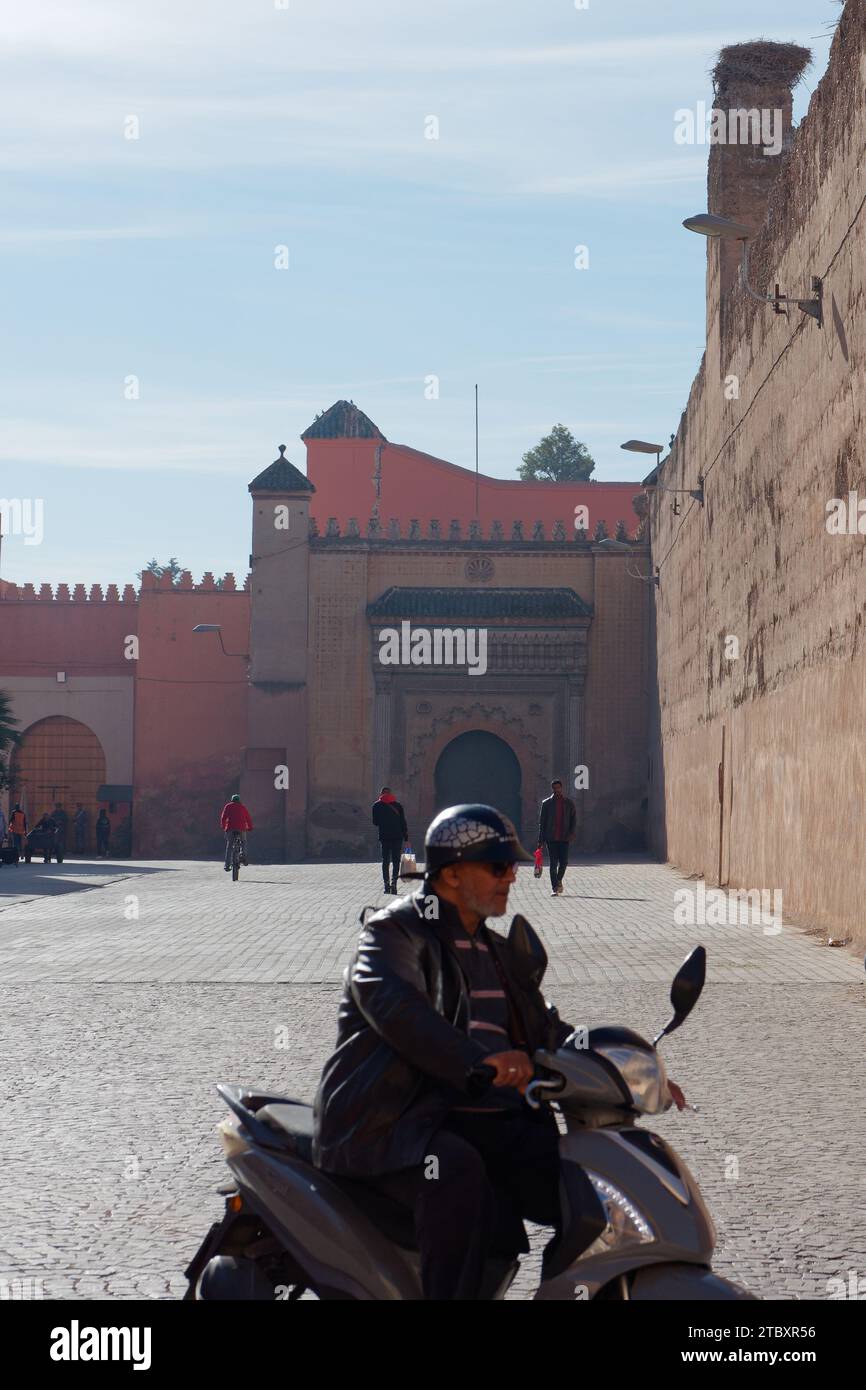 Mura del Palazzo Badi viste dalla strada all'esterno mentre un motociclista passa nella città di Marrakech, alias Marrakech, Marocco, 9 dicembre 2023 Foto Stock