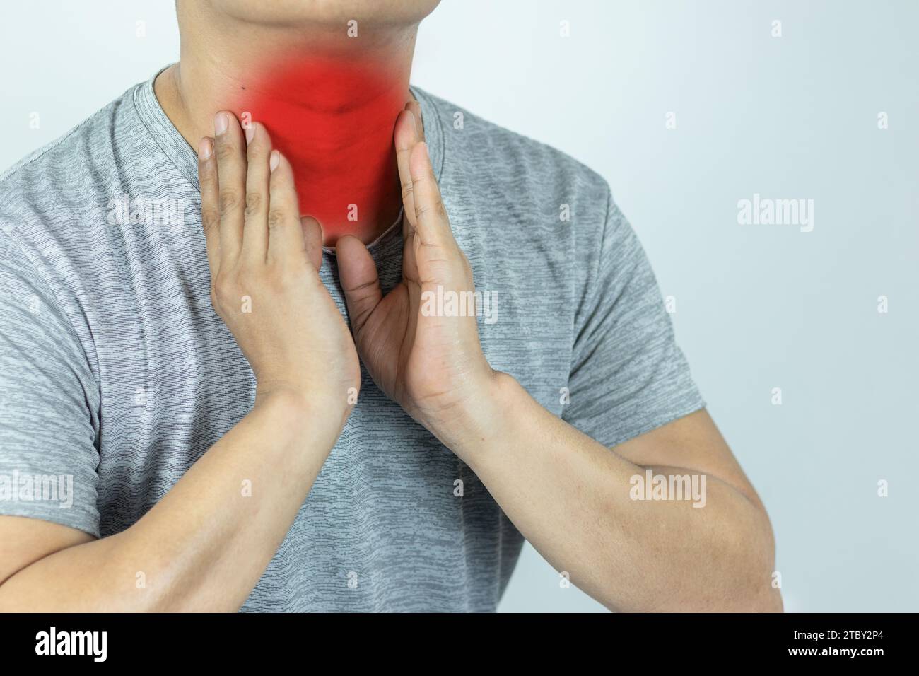 Uomo asiatico che tocca il collo con la mano perché soffre di mal di gola Foto Stock