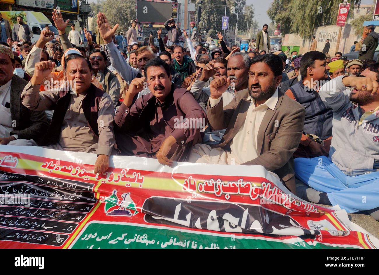 I membri di All Pakistan Wapda Hydro Electric Workers Union stanno organizzando una manifestazione di protesta per l'aumento dei loro stipendi a causa dell'aumento dei prezzi, al club stampa di Sukkur sabato 9 dicembre 2023. Foto Stock