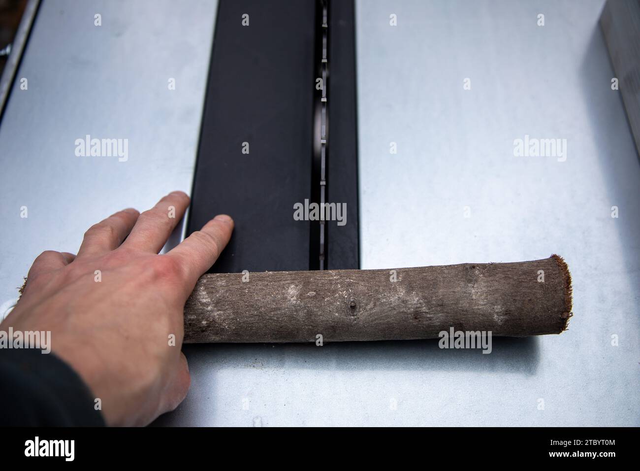 Ein Stück Holz mit einer Kreissäge zerkleinern Foto Stock