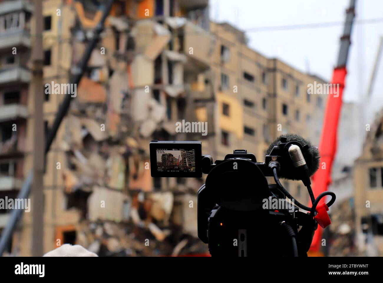 Le trasmissioni televisive professionali vivono vicino alla casa distrutta dal razzo russo nella città di Dnipro. Russia guerra contro l'Ucraina, Dnipro Live trasmissione di nuovo Foto Stock