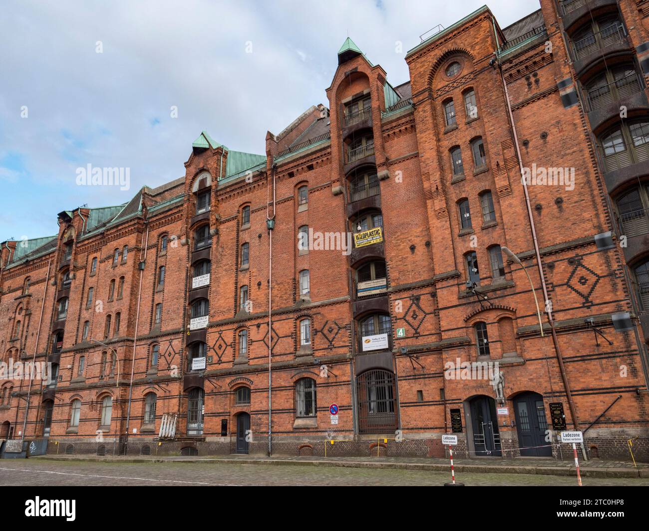 Vista generale di uno dei grandi magazzini in mattoni rossi (ora convertiti in uffici, ecc.) nel quartiere Speicherstadt di Amburgo, Germania. Foto Stock