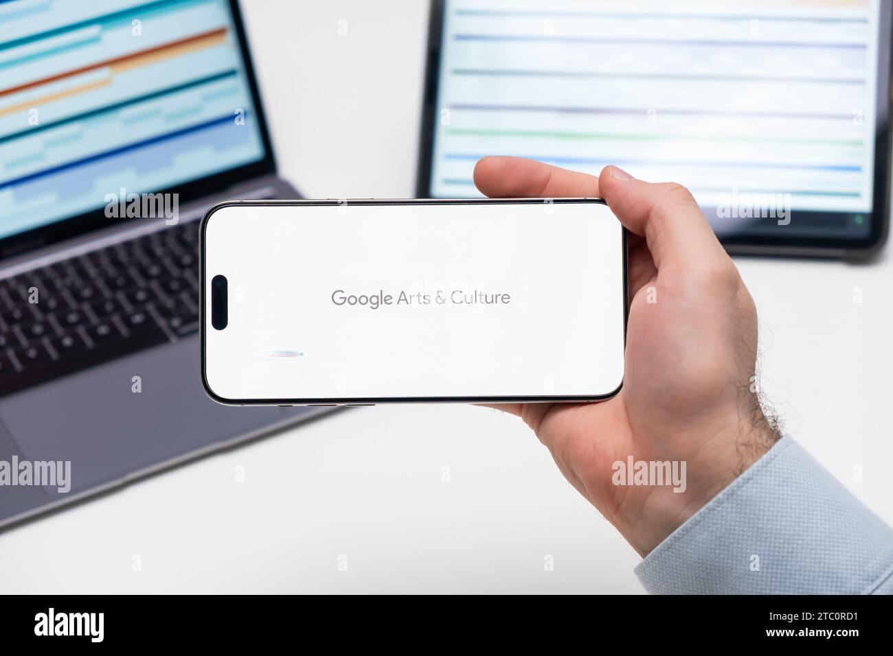 Logo Google Arts and Culture sullo schermo di uno smartphone in mans Hand con laptop e tablet con diagrammi grafici sullo sfondo, dicembre 2023, Praga, Repubblica Ceca. Foto Stock