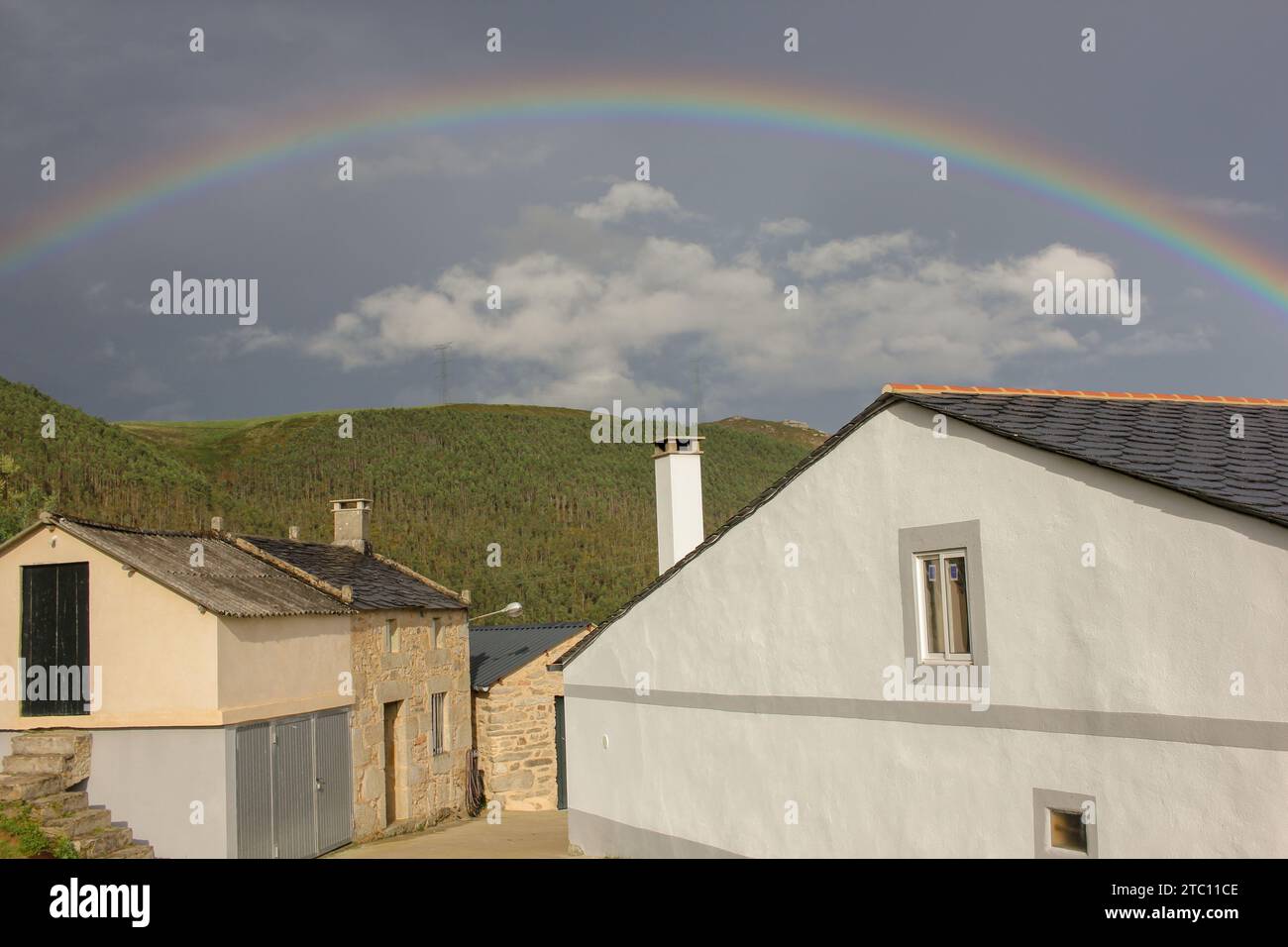 arcobaleno su alcune case in montagna Foto Stock