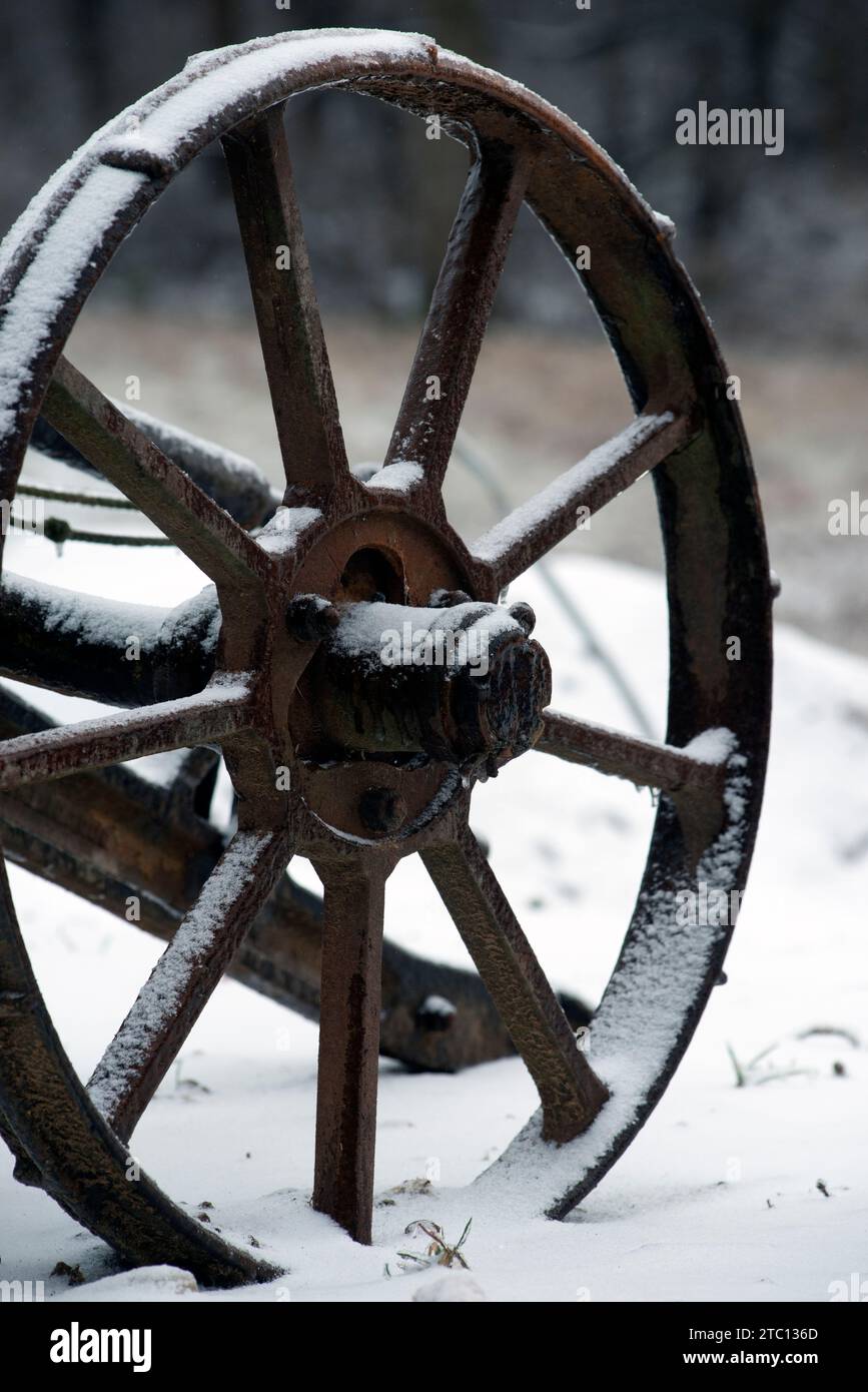 Un antico aratro in un campo durante una tempesta di ghiaccio e neve Foto Stock