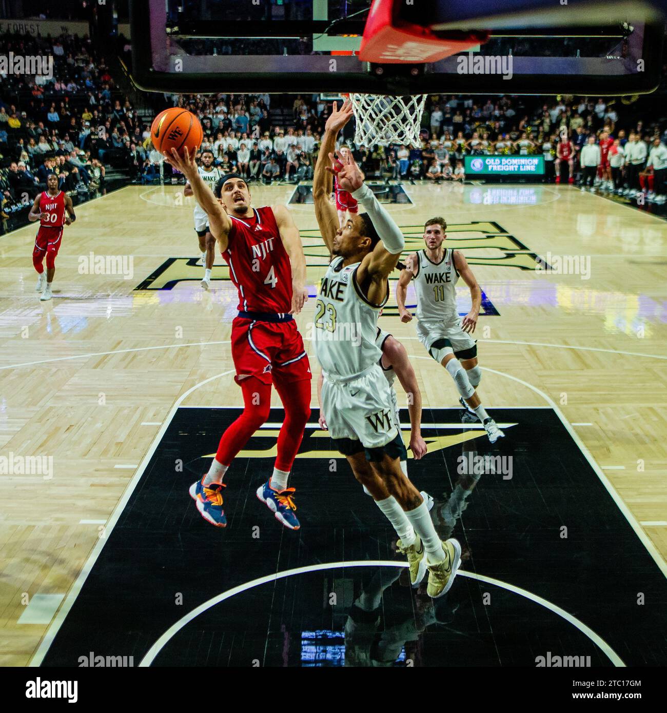 9 dicembre 2023: La guardia N.J.I.T Highlanders Adam Hess (4) spara alla guardia dei Demon Deacons Wake Forest Hunter Sallis (23) durante la prima metà del match di basket NCAA al LJVM Coliseum di Winston-Salem, NC. (Scott Kinser/CSM) Foto Stock