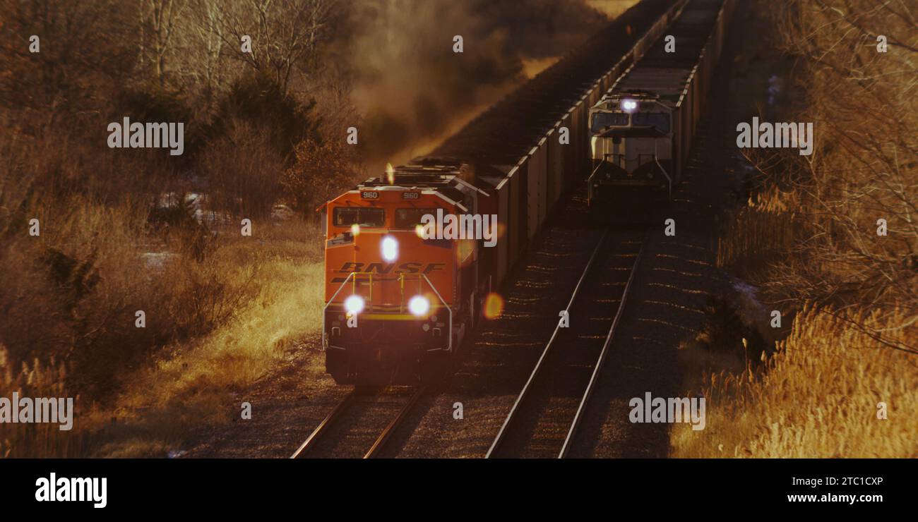 Il treno merci fa esplodere la campagna pastorale e deforma l'aria con scarico super riscaldato nel Midwest rurale con il suo splendido fogliame autunnale. Foto Stock