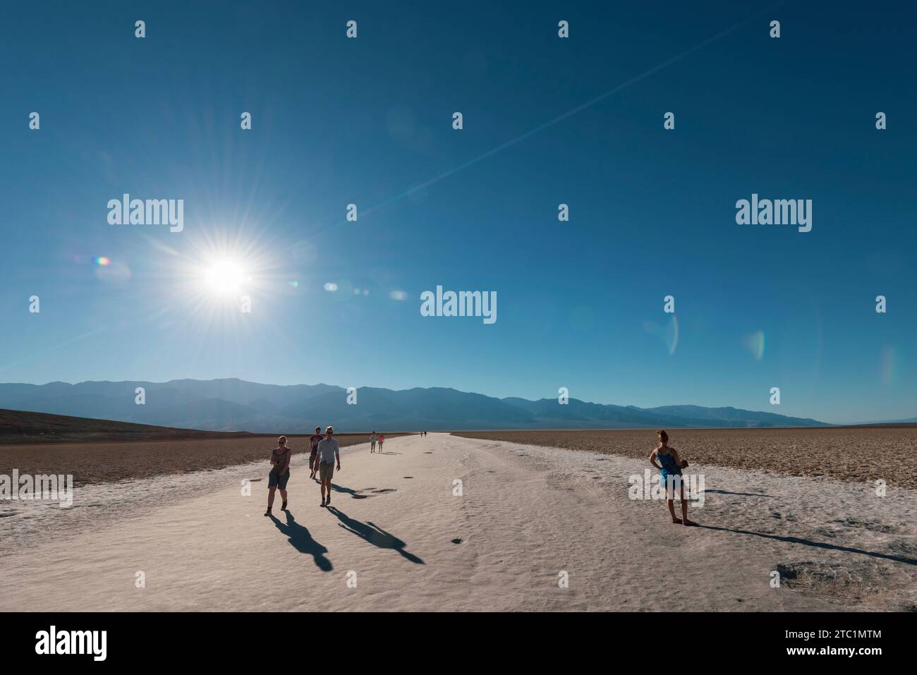 I turisti tornano dall'esplorazione della salina intorno al bacino di Badwater nella Death Valley in California USA Foto Stock
