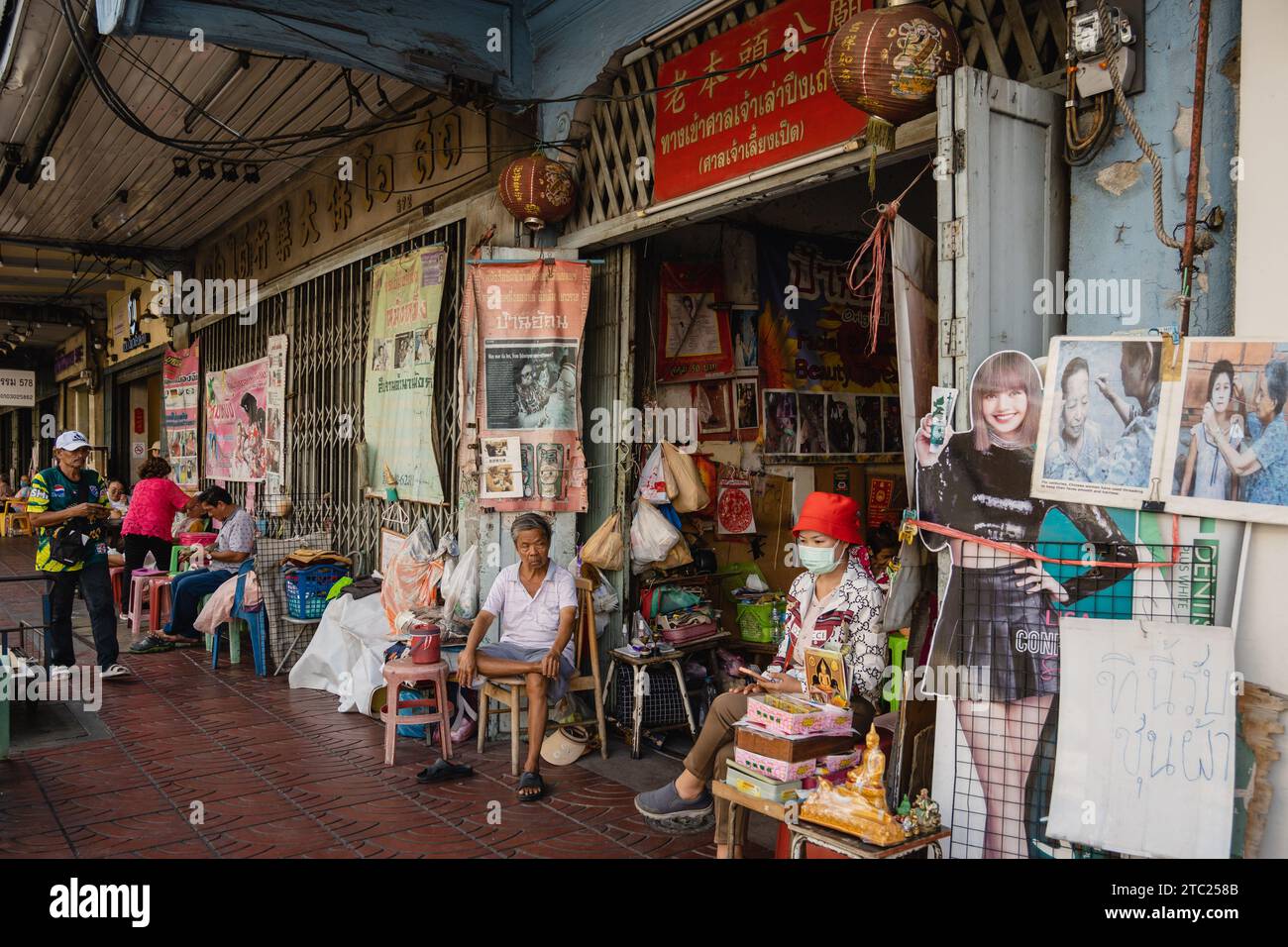 Bangkok, Thailandia. 8 dicembre 2023. All'ingresso di un santuario sulla Charoen Krung Road si trova un salone di bellezza per trattamenti viso e massaggi. Chiamato "mang ming" in tailandese, il threading del viso è un antico metodo di depilazione originario della Cina, dell'India e del mondo arabo. Il metodo utilizza fili di cotone sottili come alternativa alla ceretta o alla pinzatura delle sopracciglia sottili e rimuove i peli superflui del viso. (Foto di Nathalie Jamois/SOPA Images/Sipa USA) credito: SIPA USA/Alamy Live News Foto Stock