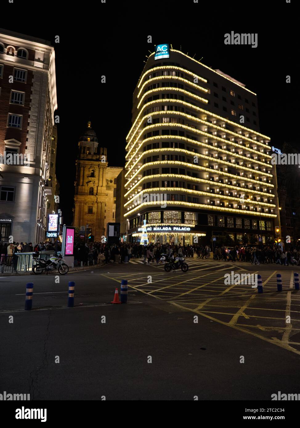 Málaga, Spagna - 8 dicembre 2023: Vista dell'Hotel AC Málaga Palacio con le luci natalizie e la cattedrale. Foto Stock