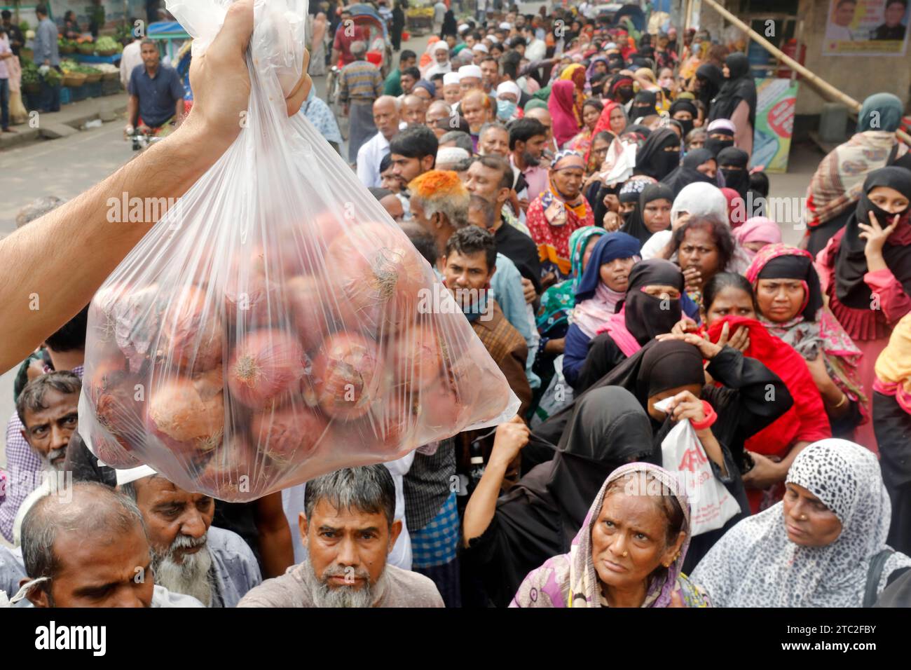 Dacca, Bangladesh - 10 dicembre 2023: Poiché il prezzo della cipolla è raddoppiato in un giorno, le persone comuni sono in fila per comprare petrolio, legumi, p Foto Stock