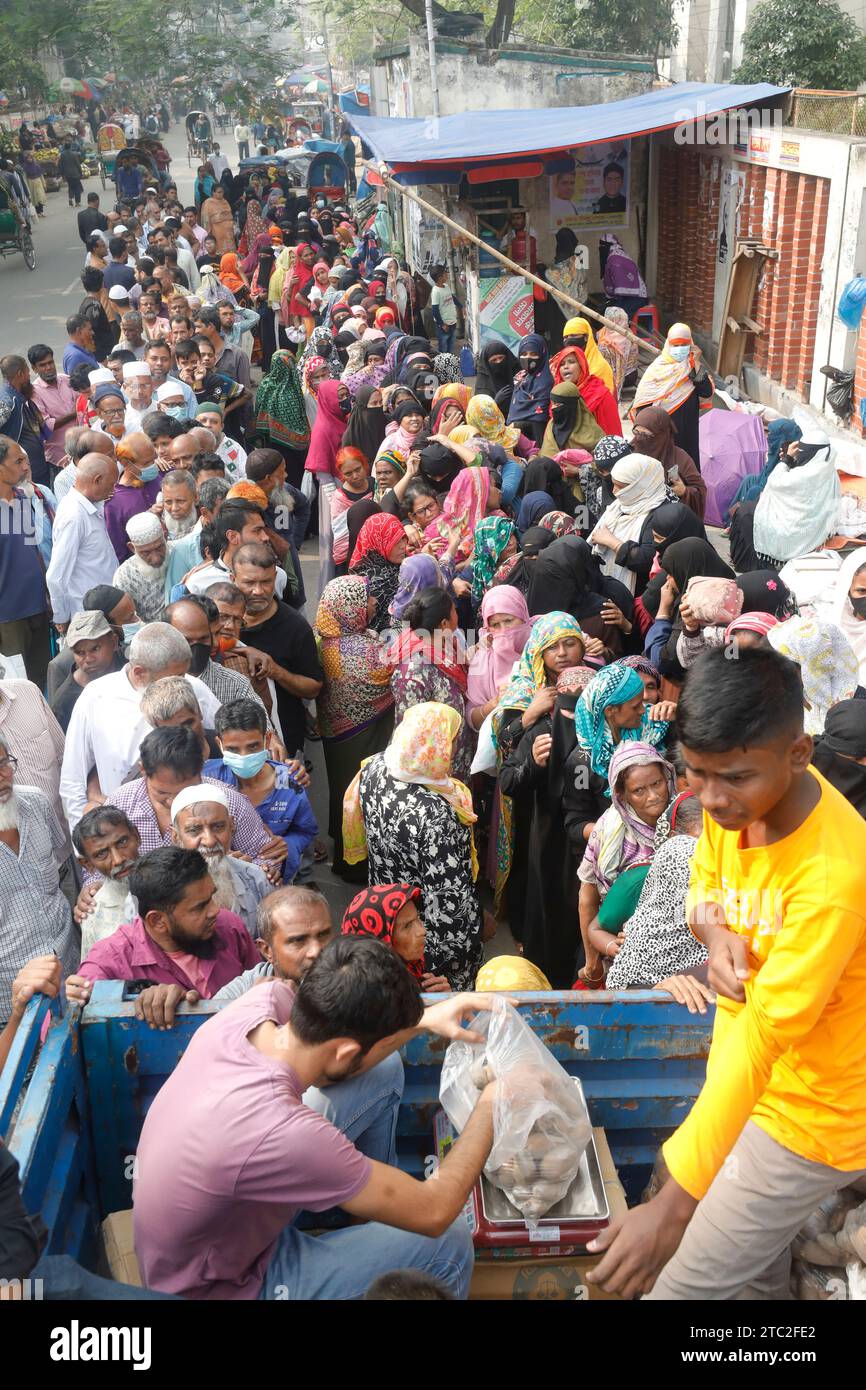 Dacca, Bangladesh - 10 dicembre 2023: Poiché il prezzo della cipolla è raddoppiato in un giorno, le persone comuni sono in fila per comprare petrolio, legumi, p Foto Stock