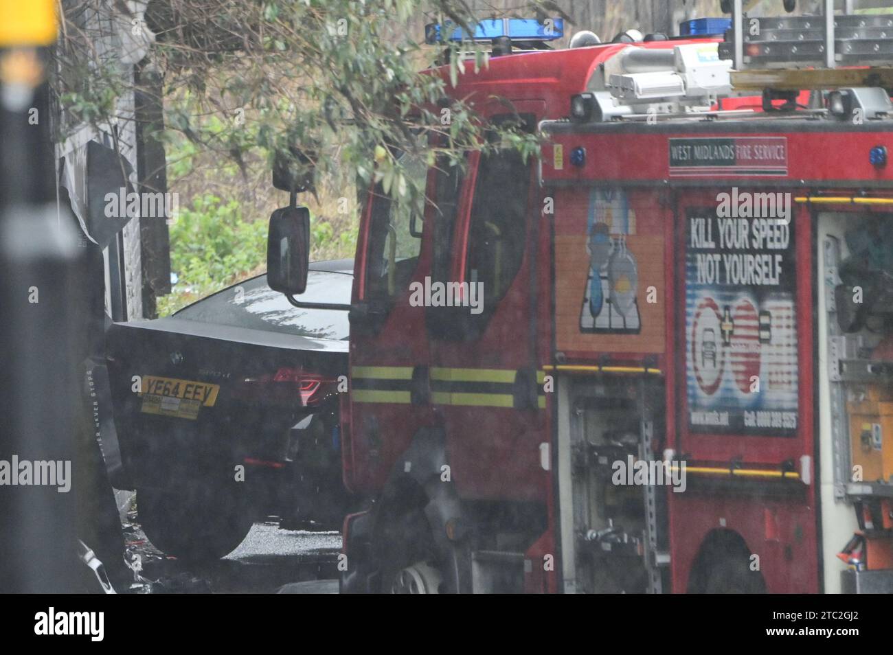 Highgate Road, Birmingham 10 dicembre 2023 - Una donna di vent'anni è morta dopo che la BMW che guidava era in collisione con un taxi nella zona di Sparkbrook a Birmingham poco prima delle 2 di domenica mattina. La polizia e i vigili del fuoco erano ancora sulla scena a mezzogiorno per indagare. Un grande schermo blu copriva l'incidente su un lato sotto un ponte ferroviario e due veicoli antincendio del supporto tecnico bloccavano l'altro lato. Credito: Stop Press Media/Alamy Live News Foto Stock