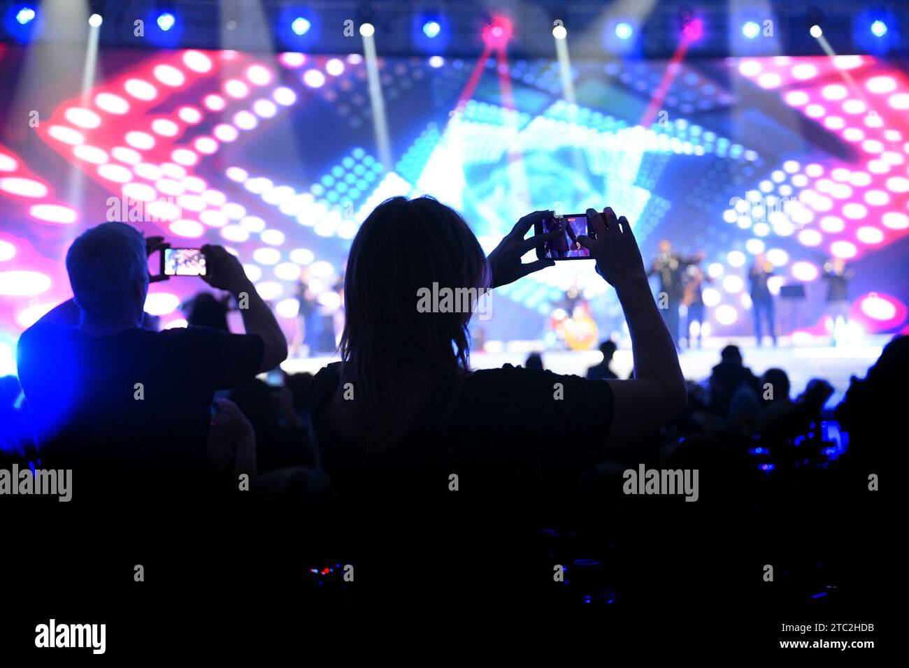 stai girando uno spettacolo con un cellulare in mano nella sala concerti. Con musica e luce del palco Foto Stock