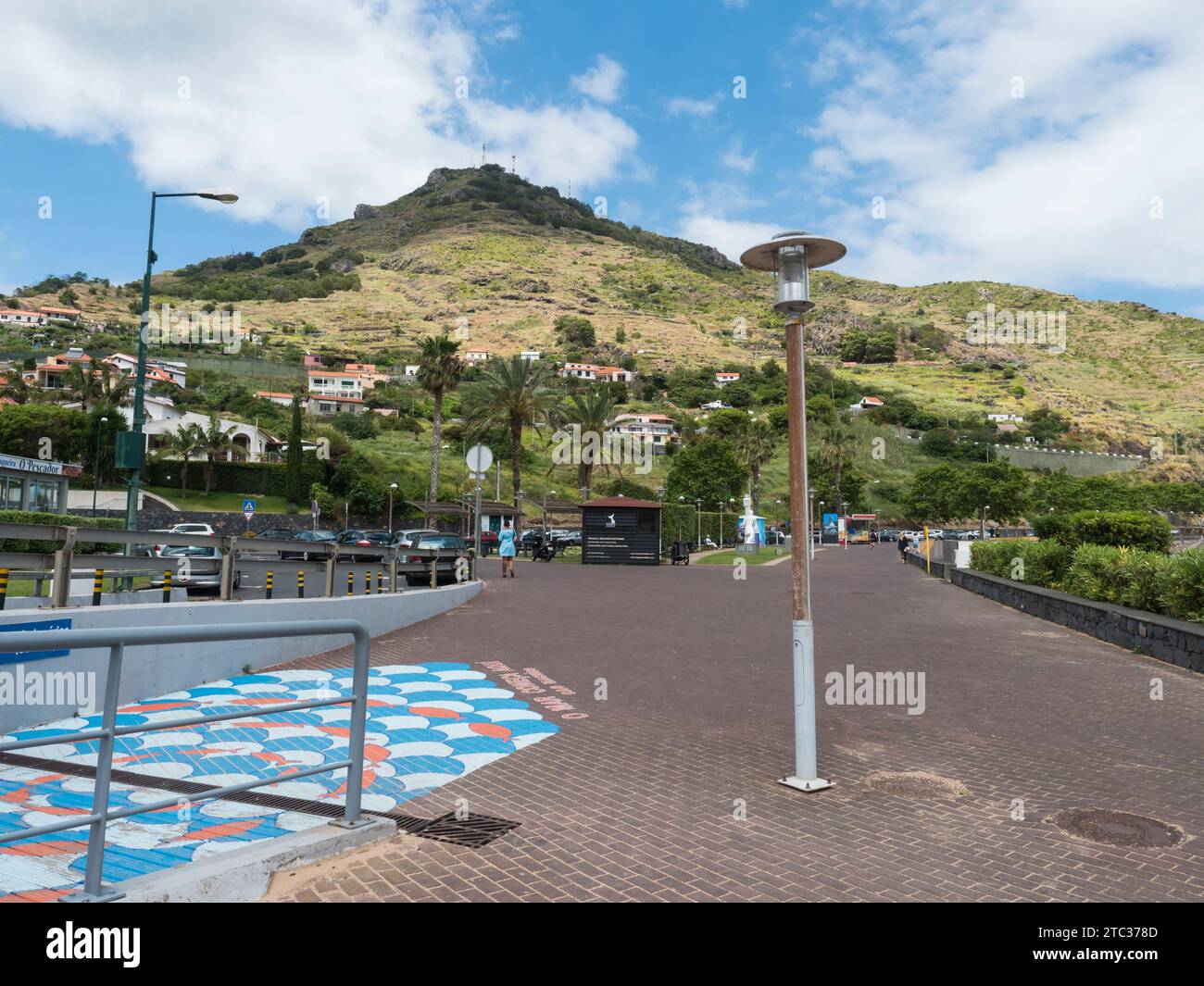 Machico, Madeira, Portogallo, 17 maggio 2022: Strada pedonale, lungomare ed edifici a Machico. Collina verde sullo sfondo Foto Stock