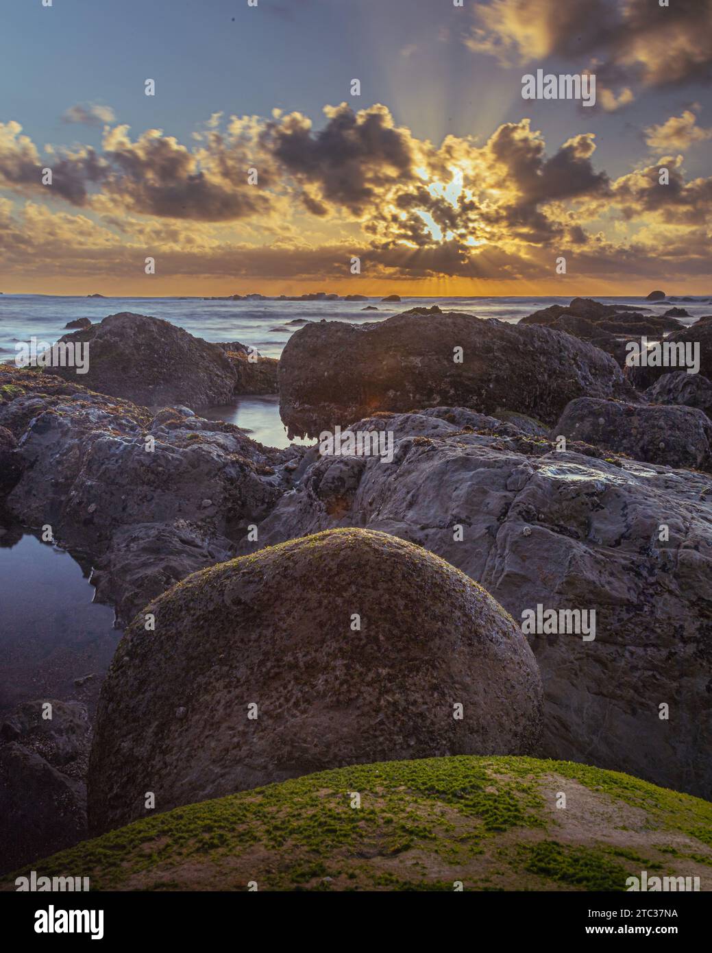 Tramonti all'orizzonte dell'oceano con una costa rocciosa a Sao Martinho do Porto, Portogallo Foto Stock