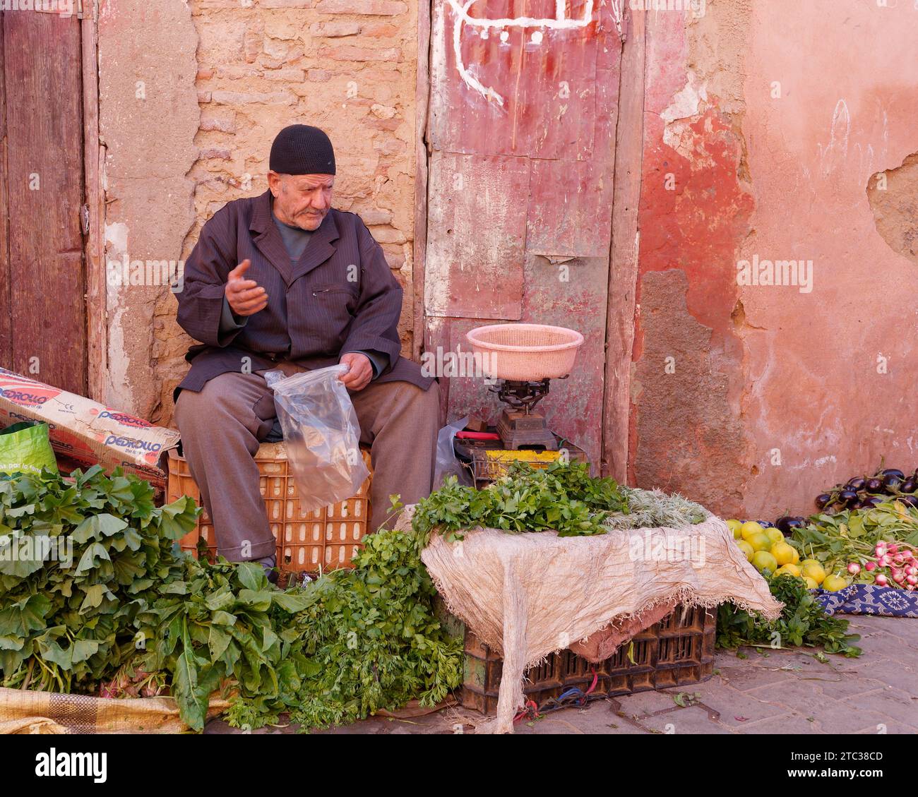 Venditore di frutta e verdura nella Medina nella città di Marrakech, alias Marrakech con la Moschea in lontananza, Marocco, 10 dicembre 2023 Foto Stock