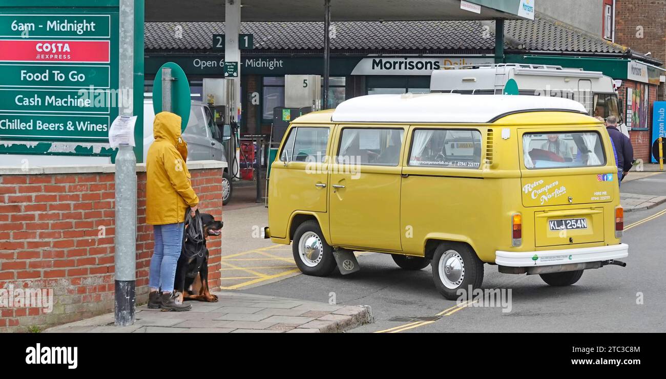 Morrisons Daily Shop e stazione di rifornimento carburante crossover e negozio di cibo da asporto VW Volkswagen camper gialli, camper, camper, camper e cani che aspettano di attraversare Cromer UK Foto Stock