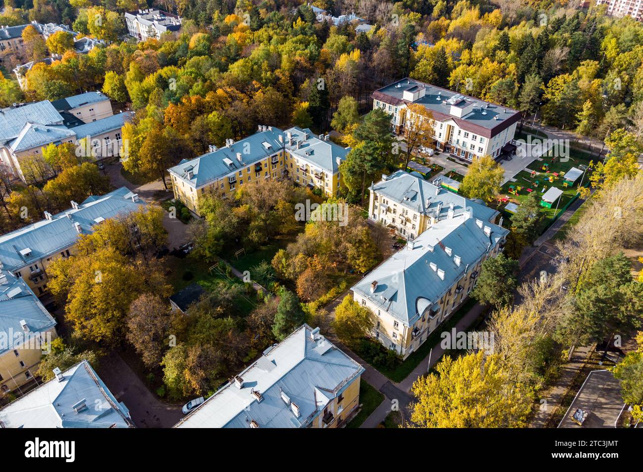 Vista aerea di un tranquillo cortile in una zona residenziale della città e di un asilo sullo sfondo Foto Stock