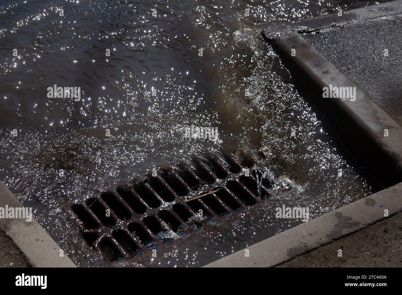 Flusso d'acqua durante la pioggia intensa e intasamento delle acque reflue stradali. Il flusso d'acqua durante un forte uragano nelle fognature. Sistema di tempeste fognarie Foto Stock