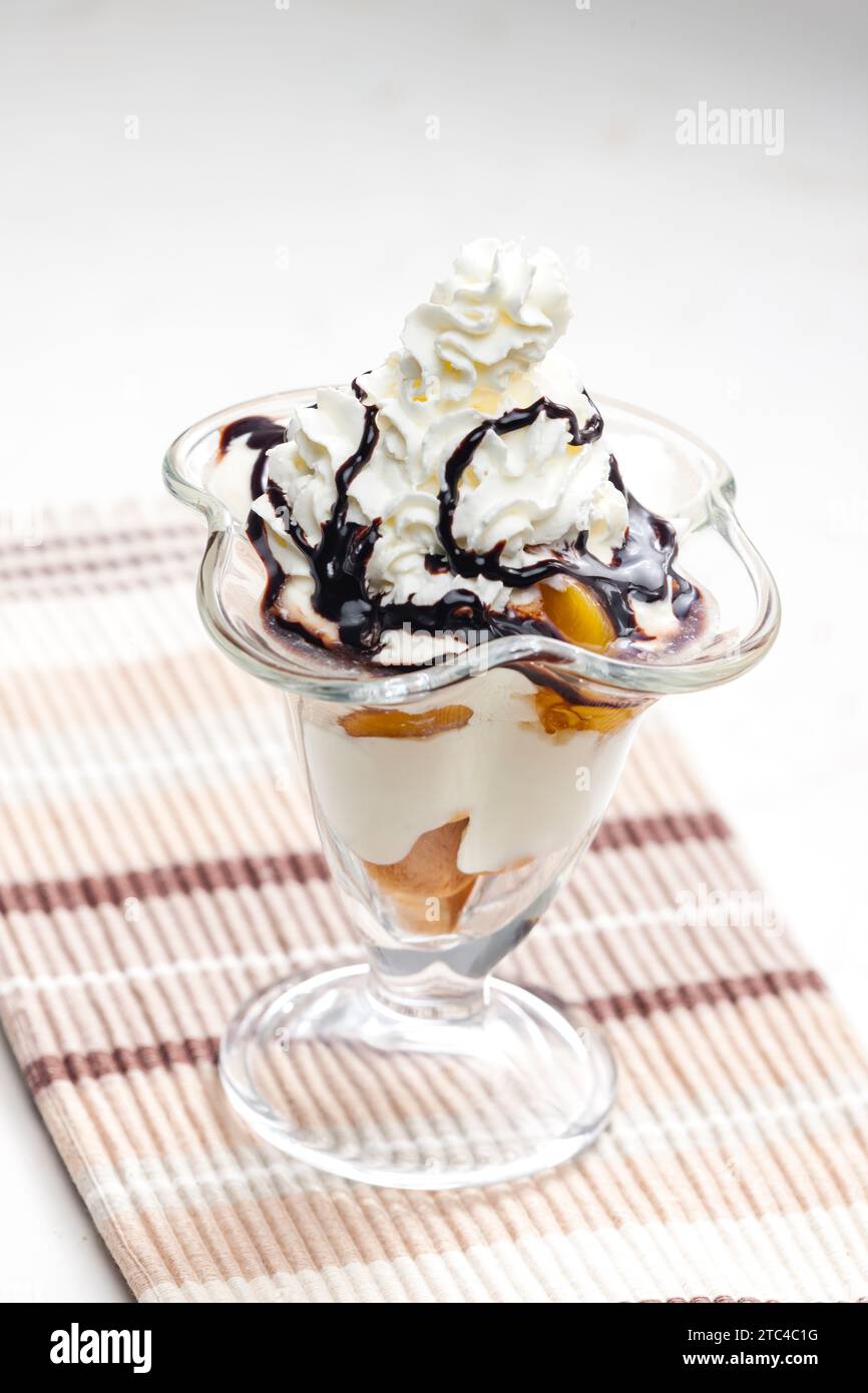 gelato con pesca stufata e panna montata Foto Stock