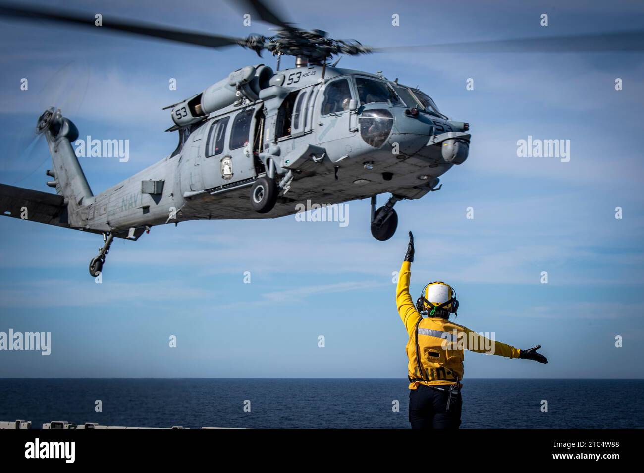 Aviation Boatswain's Mate 2nd Class Alexandria Alfordjones, nativa di Montgomery, Alabama, dirige un elicottero MH-60S Sea Hawk, assegnato alle "wildcards" dell'Helicopter Sea Combat Squadron (HSC) 23 durante le operazioni di volo a bordo della USS Boxer (LHD 4), 9 dicembre 2023. Il Boxer Amphibious Ready Group, composto da Boxer, USS Somerset (LPD 25) e USS Harpers Ferry (LSD 49), e la 15th Marine Expeditionary Unit imbarcato stanno conducendo operazioni integrate di addestramento e di routine nella 3rd Fleet degli Stati Uniti. (Foto della Marina degli Stati Uniti di Mass Communication Specialist 2nd Class James Finney) Foto Stock