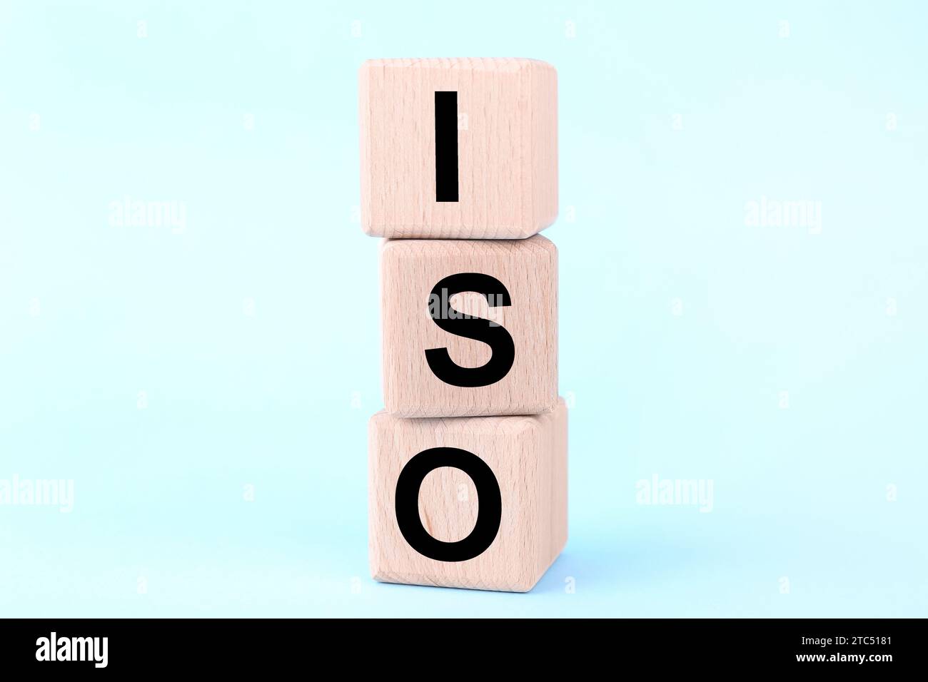 International Organization for Standardization (Organizzazione internazionale per la standardizzazione). Cubi in legno con abbreviazione ISO su sfondo azzurro chiaro, primo piano Foto Stock
