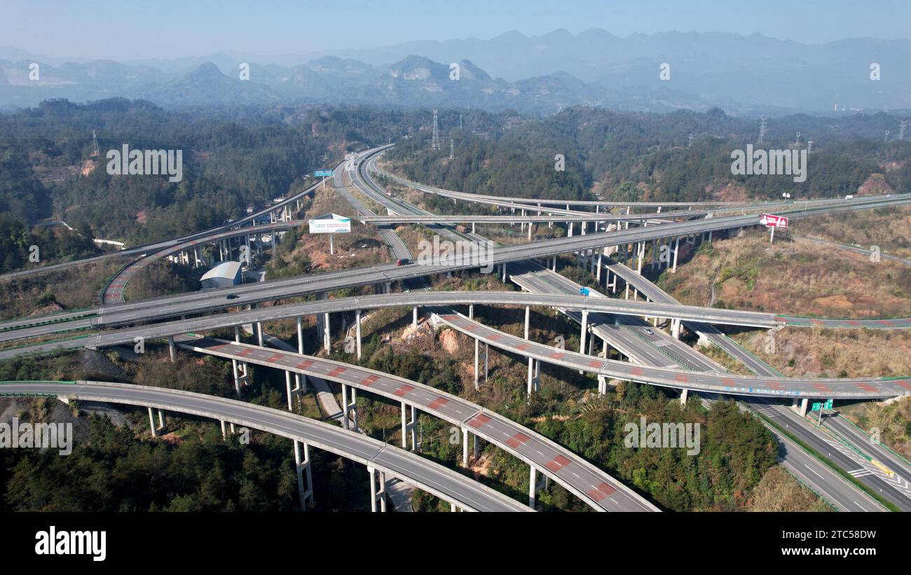 ENSHI, CINA - 7 DICEMBRE 2023 - la foto aerea mostra una linea ad alta velocità tra le montagne nella città di Enshi, provincia di Hubei, Cina, 7 dicembre 2023. Foto Stock