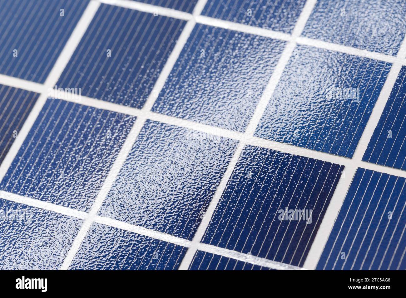 La superficie di un pannello solare con una struttura caratteristica, con un bagliore di luce. Fotografia macro Foto Stock