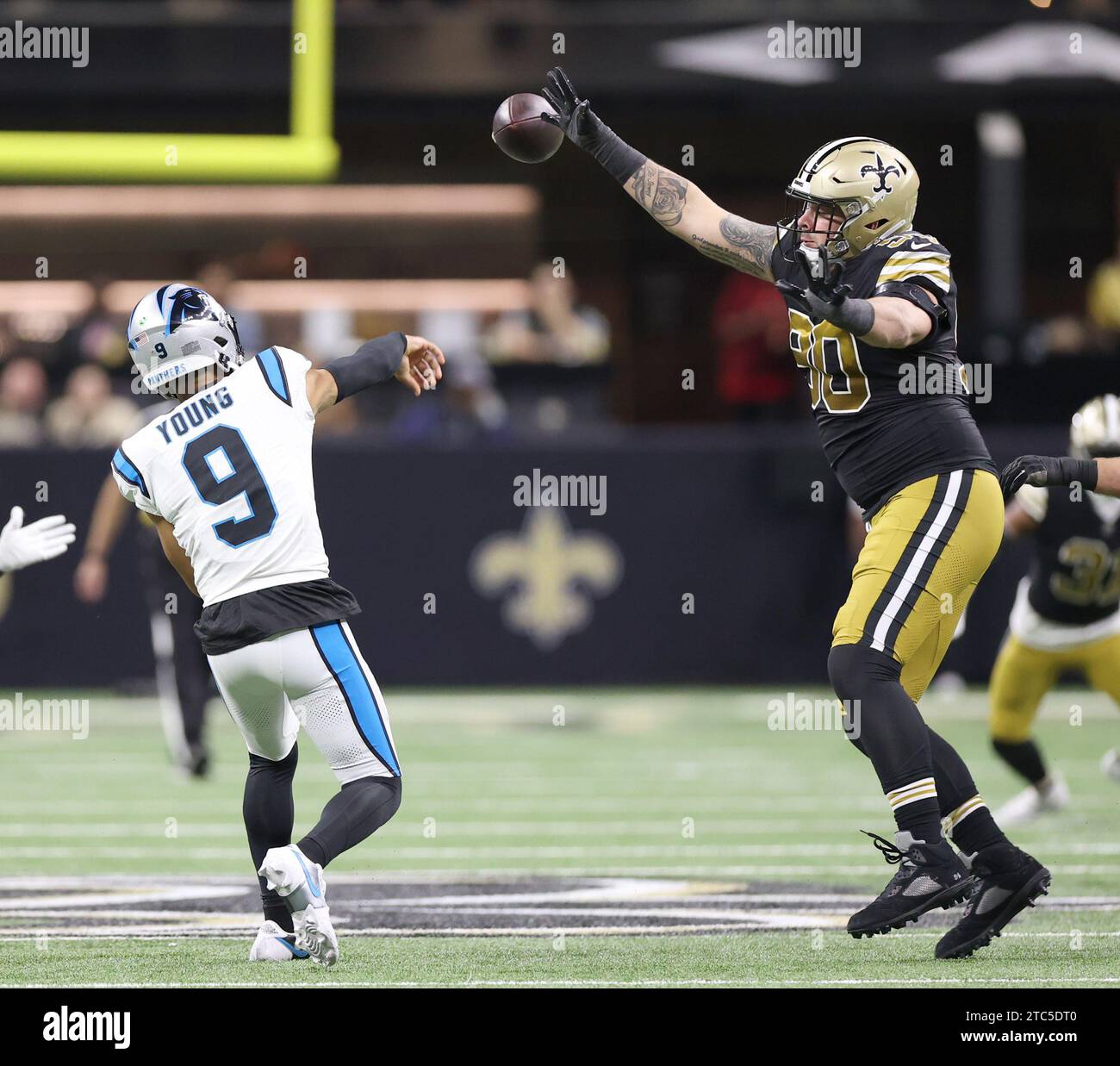 New Orleans, USA. 10 dicembre 2023. Il defensive tackle dei New Orleans Saints Bryan Bresee (90) tentò di rompere il quarterback dei Carolina Panthers Bryce Young (9) tentativo di passaggio durante una partita della National Football League al Caesars Superdome di New Orleans, Louisiana, domenica 10 dicembre 2023. (Foto di Peter G. Forest/Sipa USA) credito: SIPA USA/Alamy Live News Foto Stock