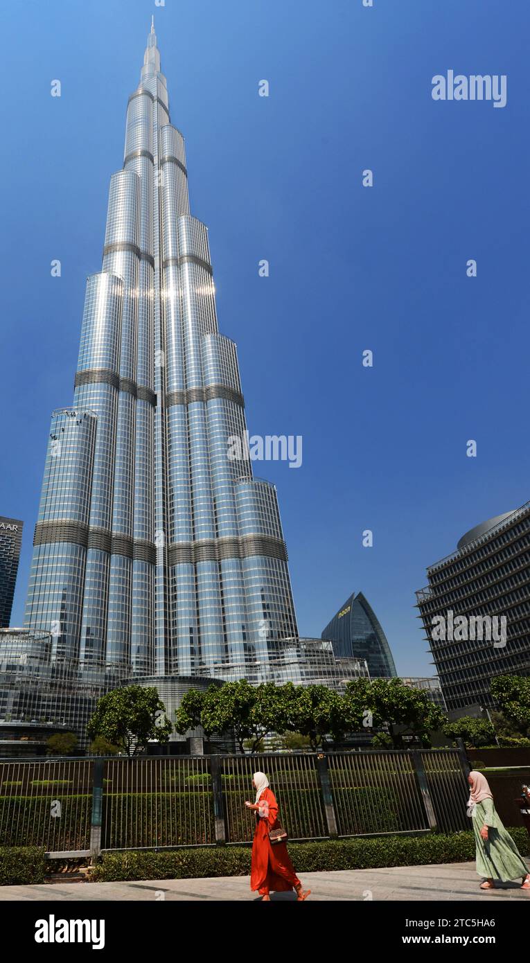 Donne indonesiane che camminano accanto al grattacielo Burj Khalifa a Dubai, Emirati Arabi Uniti. Foto Stock