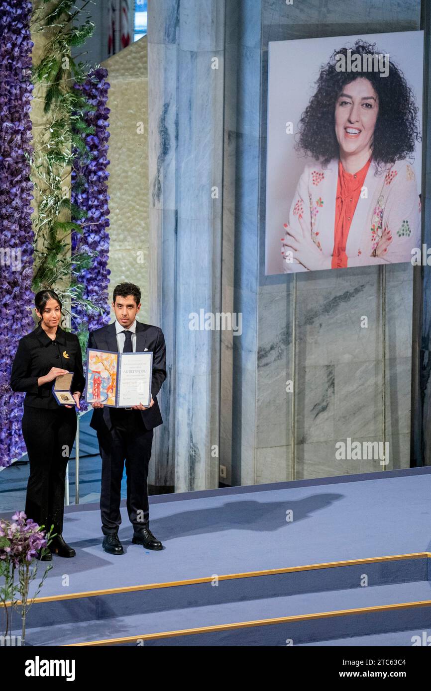 Oslo 20231210.Kiana e Ali Rahmani accettano il Premio Nobel per la pace a nome della madre Narges Mohammadi durante l'assegnazione del Premio Nobel per la pace per il 2023 al municipio di Oslo domenica. Il Premio Nobel per la pace 2023 viene assegnato all'iraniana Narges Mohammadi per la sua lotta contro l'oppressione delle donne in Iran e la sua lotta per i diritti umani e la libertà per tutti. Narges Mohammadi è imprigionato in Iran, e il premio è accettato dai suoi due figli Ali e Kiana e da suo marito Taghi Rahmani. Foto: Fredrik Varfjell / NTB Foto Stock