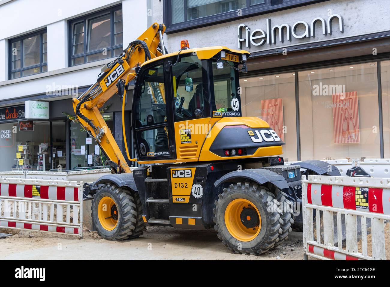 Lussemburgo, Lussemburgo - escavatore gommato giallo JCB Hydradig 110W in cantiere. Foto Stock