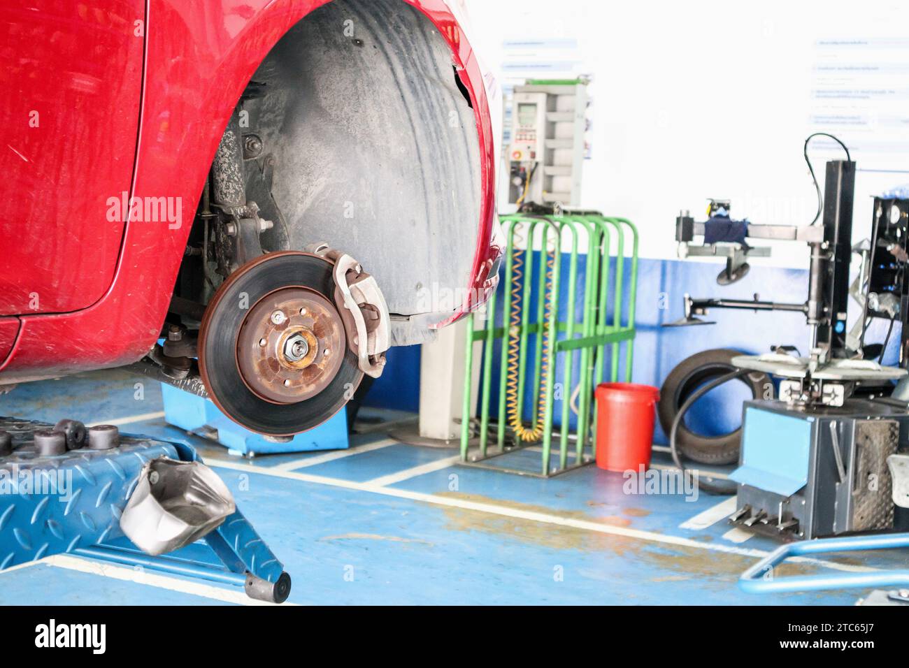 Servizio di sostituzione degli pneumatici, freno a disco per auto senza primo piano delle ruote presso un'officina di riparazione automatica Foto Stock