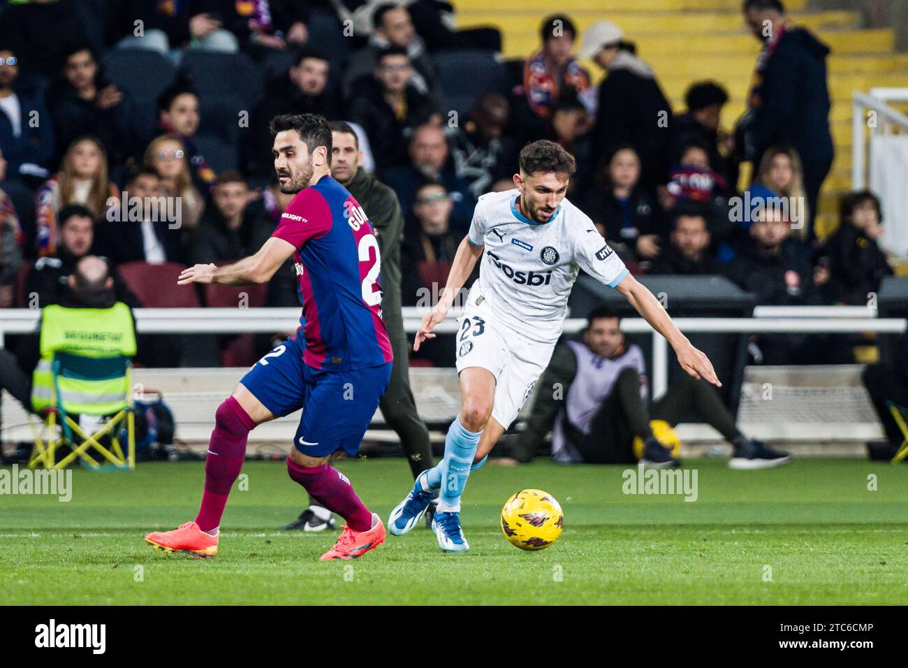 Ivan Martin del Girona FC in azione contro Ilkay Gundogan del FC Barcelona durante la partita di calcio del campionato spagnolo la Liga tra FC Barcelona e Girona FC l'11 dicembre 2023 all'Estadi Olimpic de Montjuic di Barcellona, Spagna Foto Stock