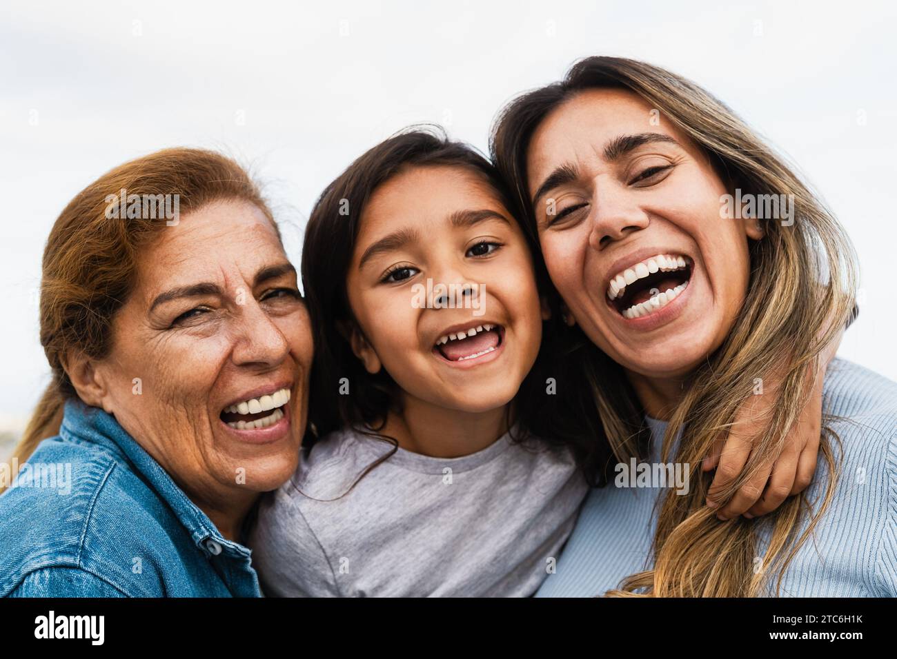 Felice famiglia ispanica multigenerazionale sorridente nella fotocamera - bambino che si diverte con la madre e la nonna all'aperto Foto Stock