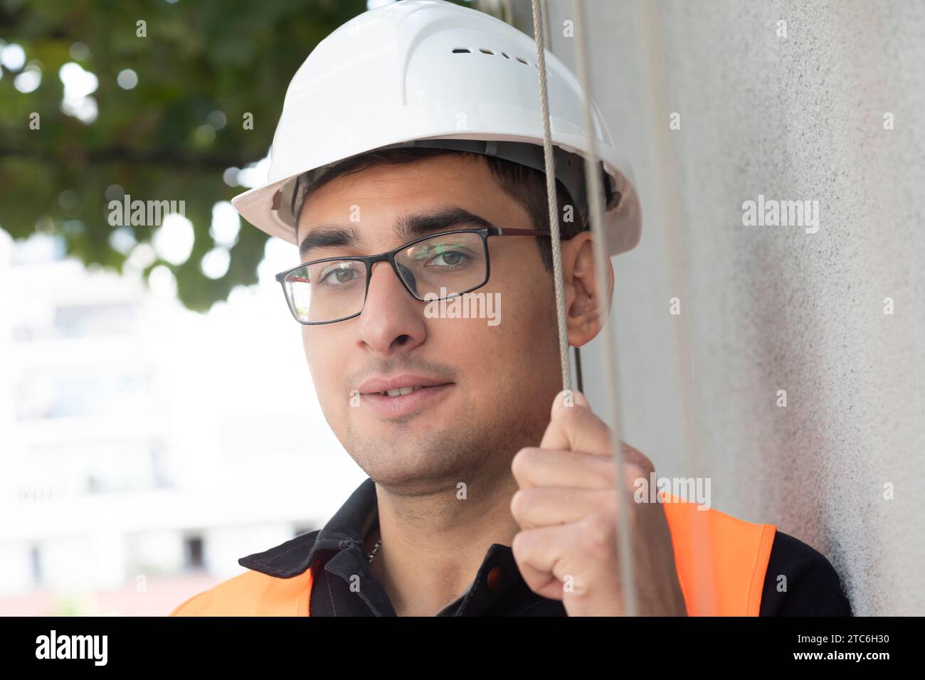 tecnico maschio con casco in piedi vicino a un edificio Foto Stock